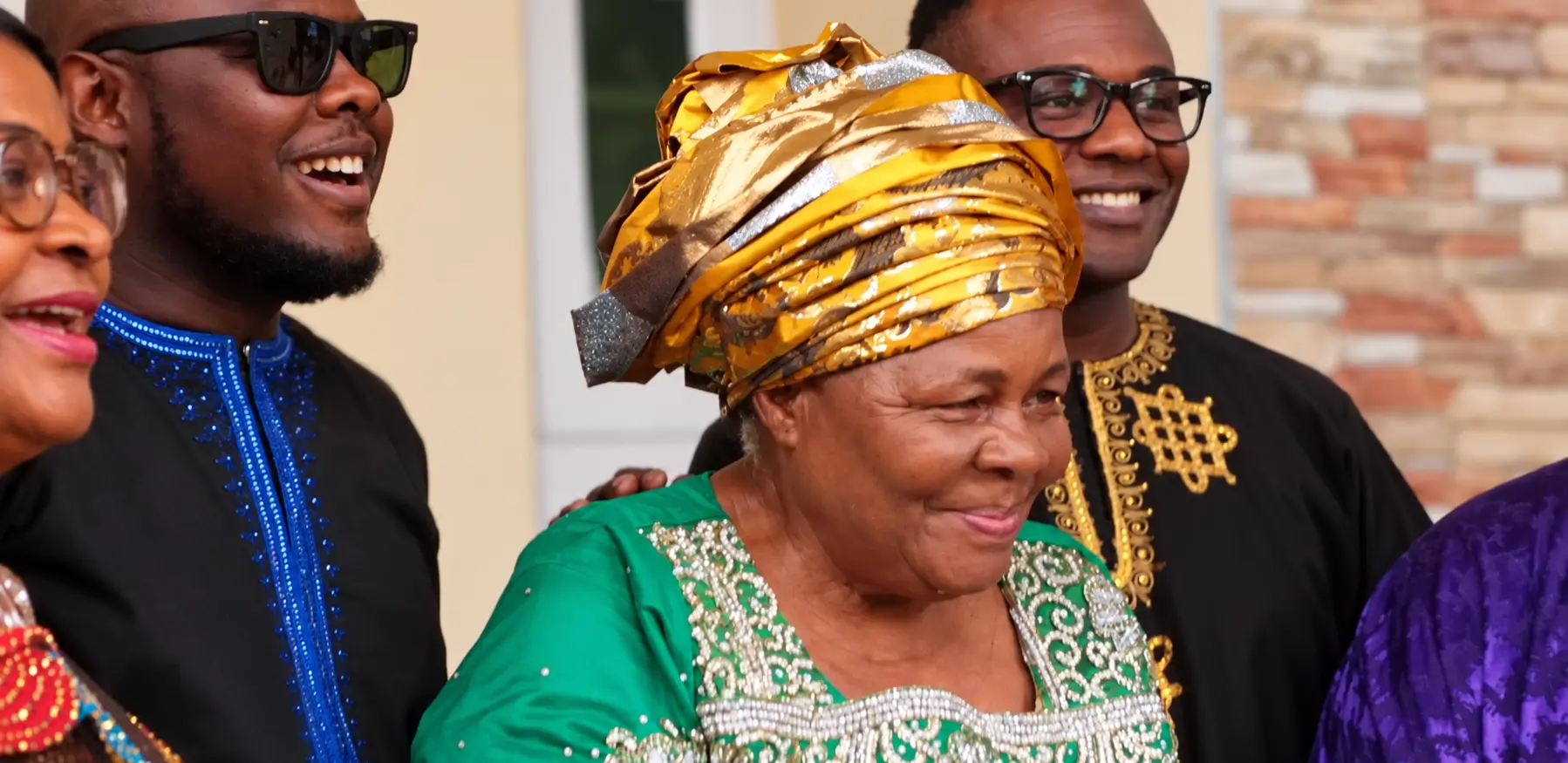 Betty Nnenna Nwakaego in green and a gold headwrap with family at her 70th birthday celebration at Nda Chi’s home in Abuja, 2018